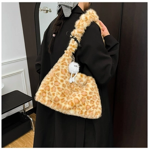 Detail of plush leopard print faux fur tote bag featuring a cute monster charm accessory