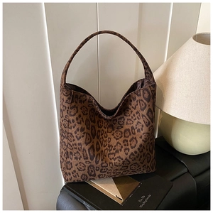 Leopard print tote bag displayed on a bench next to a stylish pleated lamp decor