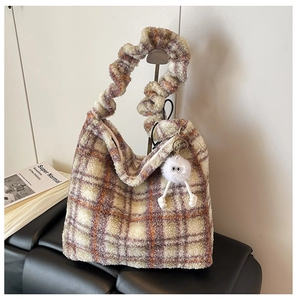 Détail du sac fourre-tout en peluche à carreaux orange avec breloque poupée douce