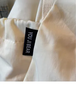 Detail of high-density fabric drawstring bag featuring a black woven brand logo label