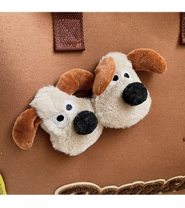 Gros plan du détail du chiot en peluche 3D sur le sac fourre-tout en toile marron