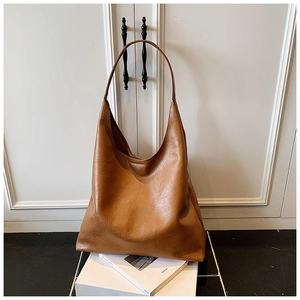 Détail d'un grand sac hobo marron montrant sa texture en cuir souple et sa bandoulière