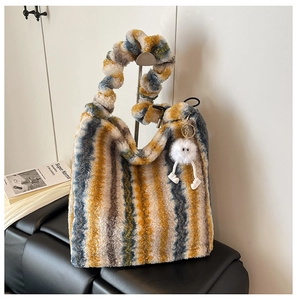 Détail du sac fourre-tout en peluche rayé avec anses douces et breloque mignonne