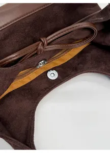Internal view of bucket bag showing magnetic snap closure and suede lining