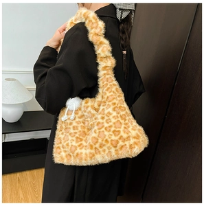 Detailed texture of fluffy giraffe print shoulder bag with a soft white pompom charm