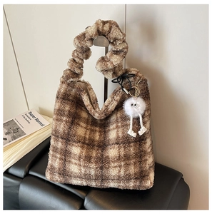 Détail du sac cabas en peluche à carreaux avec charm pompon et poignée froncée