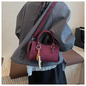 Détail du sac bandoulière bordeaux givré avec perles décoratives en bois multicolores