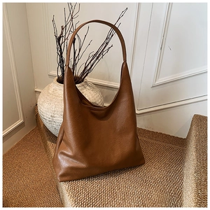 Gros plan détaillé d'un sac cabas marron en cuir texturé sur fond rustique artistique