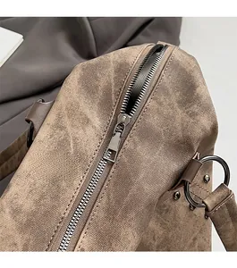 Close-up of smooth silver zipper and durable metal ring on vintage brown tote bag