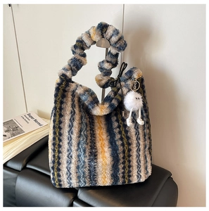 Détail macro du sac cabas rayé en peluche avec texture laine et poignée froncée