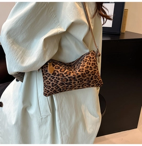 Detailed view of leopard print crossbody bag with slim strap on a trench coat