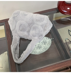 Detail of grey faux fur tote bag showing the textured circular pattern and soft plush fabric