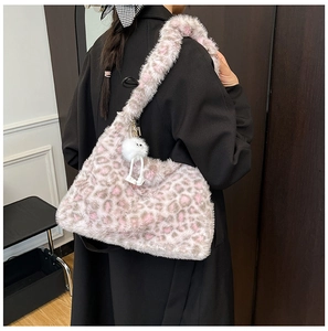 Detail view of pink leopard print plush shoulder bag with a fluffy monster keychain