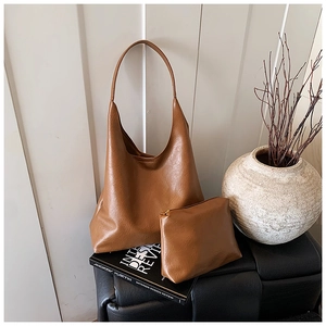 Détail du grand sac hobo marron caramel avec texture plissée et sa pochette assortie