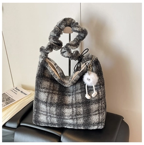 Détail du cabas en peluche à carreaux gris avec anse à volants et charm monstre blanc
