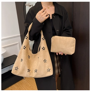 Detail of camel suede tote bag with laser-cut flower design and matching zip pouch