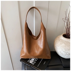 Grand sac cabas marron caramel présenté dans un décor d'intérieur minimaliste