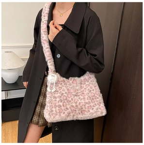 Pink leopard print plush shoulder bag with a cute white fuzzy doll charm on a wide strap