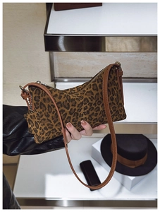 Close-up of leopard print crossbody bag with leather strap and metal zipper detail