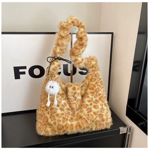 Detail of plush leopard print shoulder bag featuring a fuzzy white monster bag charm