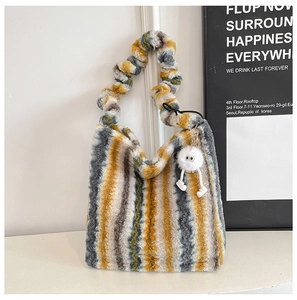 Détail du sac cabas en peluche à rayures jaune, gris et blanc avec breloque douce