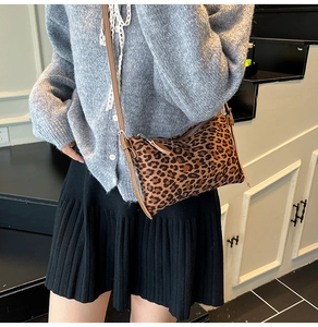 Detail shot of leopard print pillow bag with brown strap styled on a model outfit