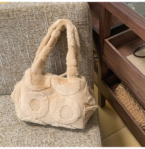 Detail of beige faux fur tote bag with unique circular textured pattern on a sofa