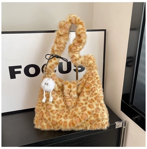 Close-up of leopard print faux fur tote bag featuring a quirky monster charm accessory