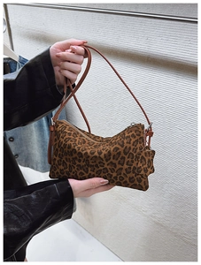 Detail of leopard print crossbody bag with star pendant and brown leather strap