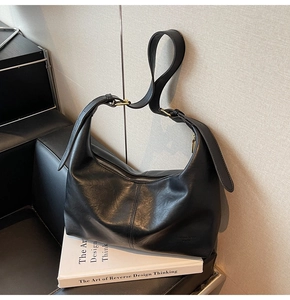 Detail view of smooth black leather hobo bag with gold buckle and embossed logo
