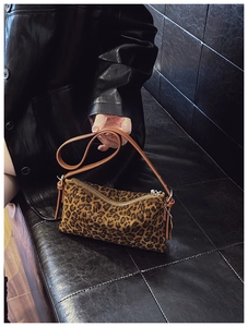 Close-up of leopard print crossbody bag featuring plush texture and silver metal zipper