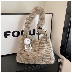 Detail of zebra pattern faux fur shoulder bag with creative plush eye charm accessory