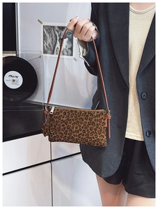 Close-up of leopard print shoulder bag featuring a sleek brown strap and metallic zipper