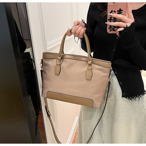 Vue détaillée du sac cabas en nylon kaki avec bordure en cuir brun et fermeture éclair