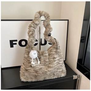 Detail of plush tote bag with faux fur stripes and a cute fluffy cartoon charm