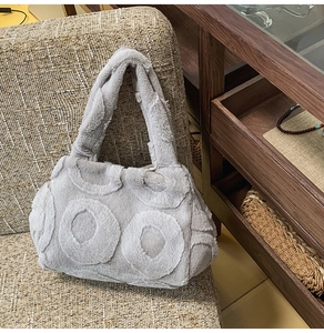Detail of grey faux fur tote bag showing unique circular plush texture on woven chair