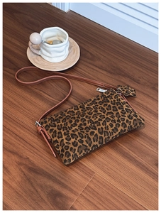 Close-up of leopard print crossbody bag featuring suede texture and leather strap details