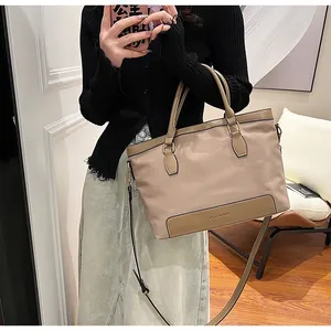Détail du sac fourre-tout en nylon avec anses en cuir et bandoulière amovible en selfie