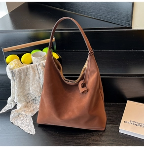 Detailed close-up of dark brown matte hobo tote bag with integrated shoulder strap