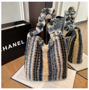 Détail du sac cabas rayé en peluche avec anse froncée et texture douce en fausse fourrure