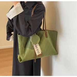 Detailed macro view of olive green quilted tote bag with brown leather shoulder straps