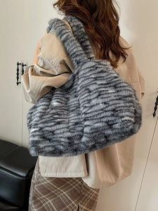 Borsa tote a righe in ecopelliccia di grande capacità mostrata a spalla con stile