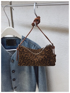 Detail of leopard print crossbody bag with star pendant and knotted shoulder strap