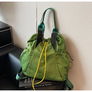 Detail view of grass green canvas tote with yellow drawstring and durable black strap