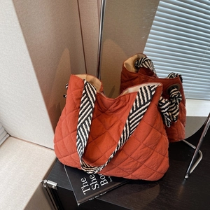 Quilted tote bag in burnt orange with diamond stitching and striped shoulder straps