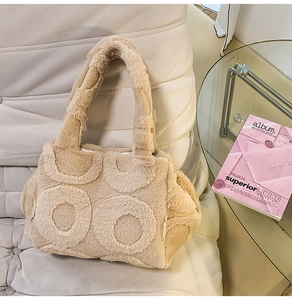 Detail of beige faux fur tote bag with embossed ring patterns on a soft quilted surface