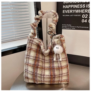 Détail du sac cabas à carreaux en peluche avec poignée froncée et breloque monstre