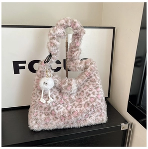 Close-up of leopard print faux fur handbag featuring a cute plush doll keychain
