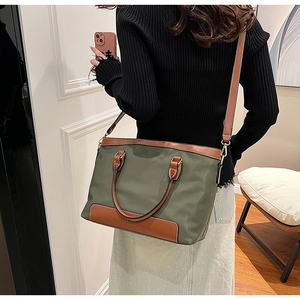 Détail du sac fourre-tout en nylon vert olive avec garniture en cuir brun et bandoulière