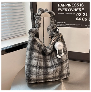 Détail du sac cabas en peluche à carreaux gris avec poignées ondulées et grigri